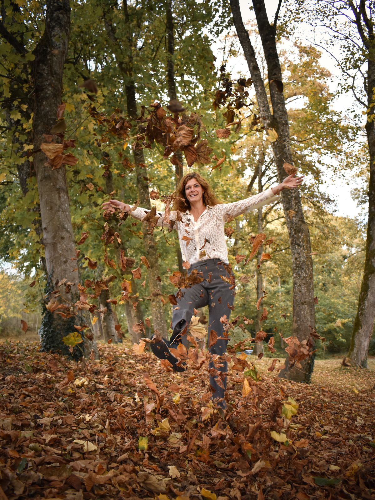 Jantine springt door de herfstbladeren